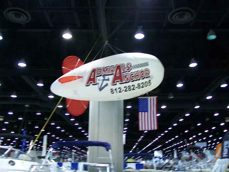 Slide: The Image of 2024 Harris Sunliner 250 at indoor boat show with Admiral's Anchor sign. - 33