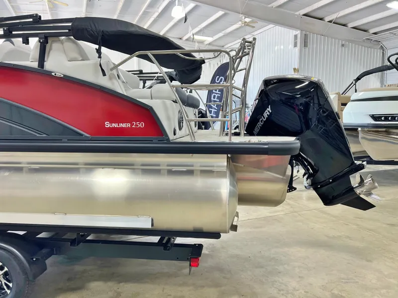 Slide: The Image of 2024 Harris Sunliner 250 pontoon boat with Mercury outboard motor in showroom. - 4