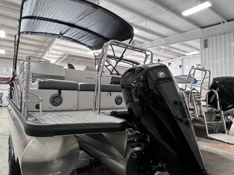 Slide: The Image of 2024 Harris Sunliner 250 pontoon boat with outboard motor in a showroom. - 5