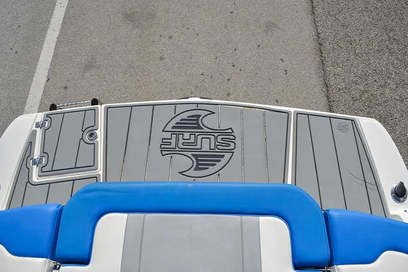 Slide: The Image of 2021 Chaparral 23 Surf boat deck with blue seating and "Surf" logo. - 11