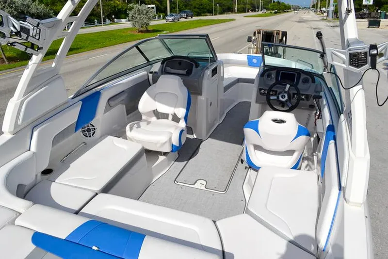 Slide: The Image of 2021 Chaparral 23 Surf boat interior with blue and white seating, modern dashboard, and spacious layout. - 14