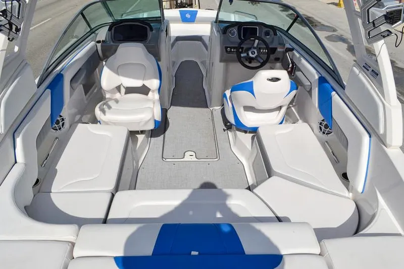 Slide: The Image of 2021 Chaparral 23 Surf boat interior with white and blue seating, modern dashboard, and spacious layout. - 15
