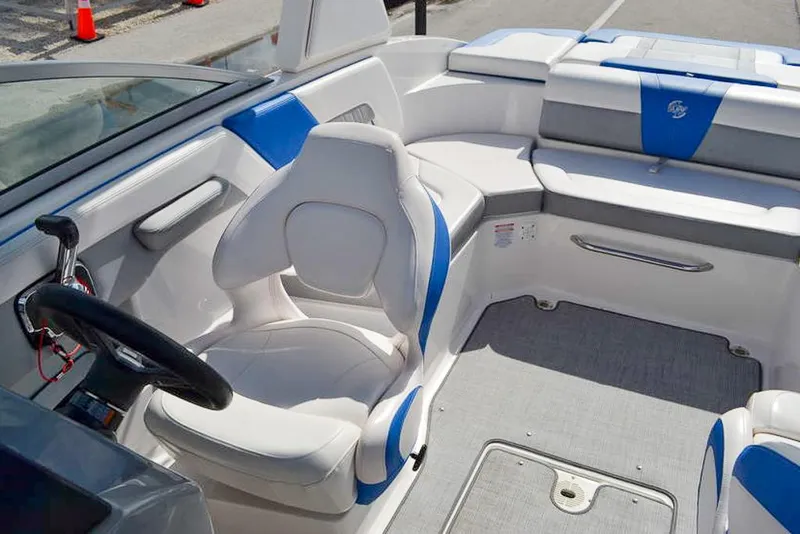 Slide: The Image of 2021 Chaparral 23 Surf boat interior with white and blue seating. - 17