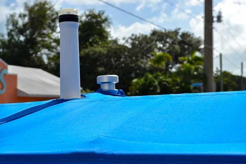 Slide: The Image of 2021 Chaparral 23 Surf boat with blue cover and visible vents. - 24