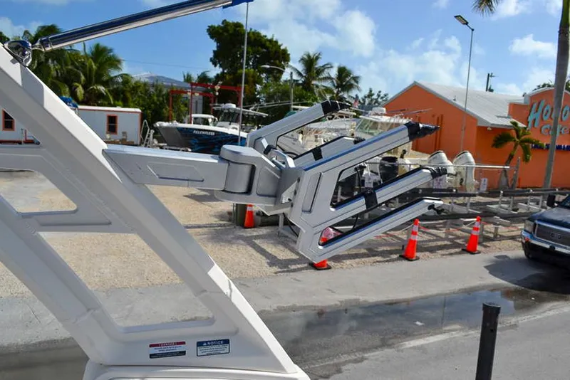 Slide: The Image of 2021 Chaparral 23 Surf boat tower with wakeboard rack in a sunny marina setting. - 27