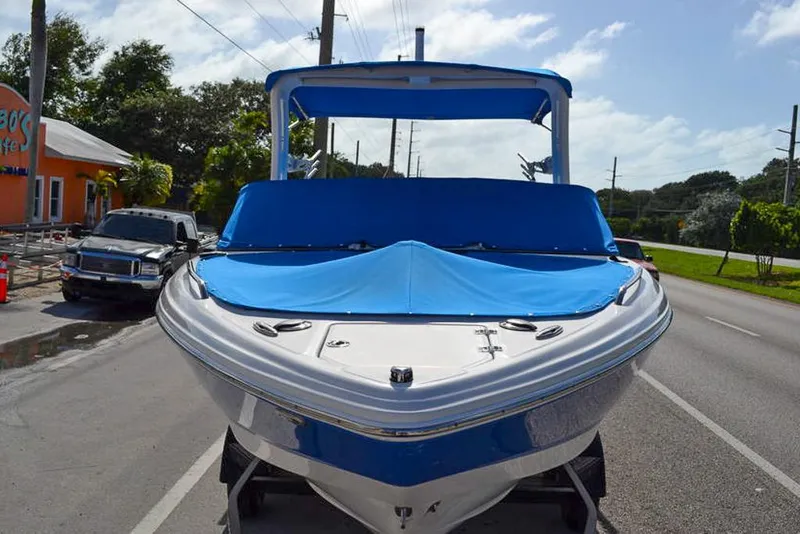 Slide: The Image of 2021 Chaparral 23 Surf boat with blue cover on a sunny street. - 3