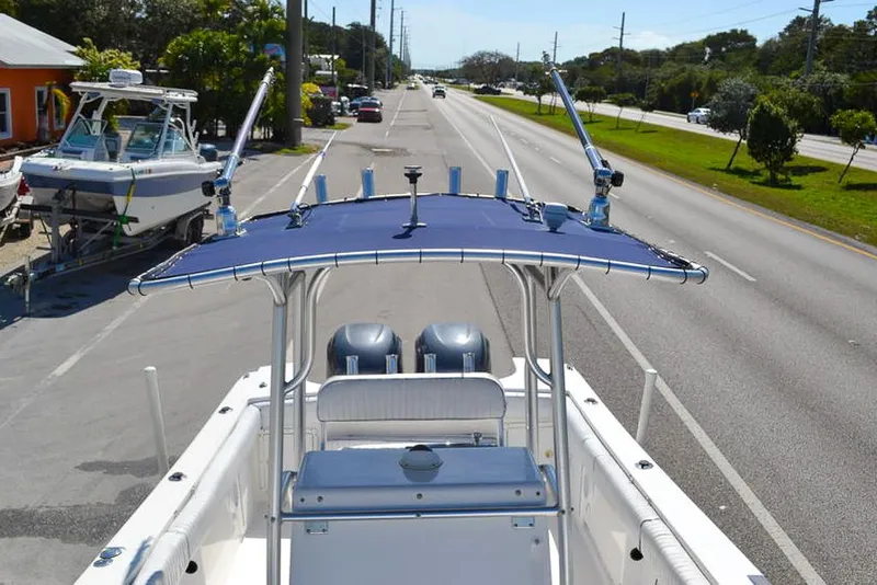 Slide: The Image of 2006 Clearwater 2500 WI CC boat with blue canopy on roadside, featuring dual engines. - 14