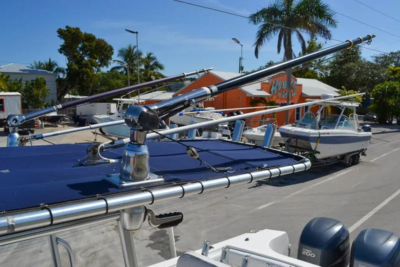 Slide: The Image of 2006 Clearwater 2500 WI CC boat with fishing outriggers, parked near palm trees and buildings. - 16