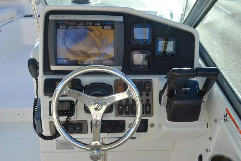 Slide: The Image of Control panel of 2011 Glacier Bay 2740 Dual Console boat with steering wheel and navigation display. - 17