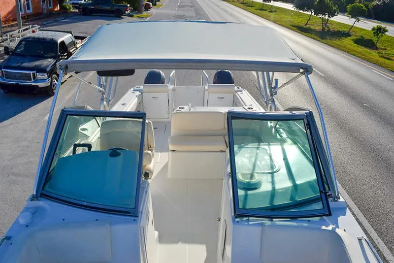 Slide: The Image of 2011 Glacier Bay 2740 Dual Console boat with canopy, parked on a sunny street. - 27