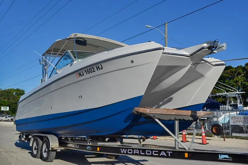 Slide: The Image of 2011 Glacier Bay 2740 Dual Console boat on trailer, blue and white design, parked outdoors. - 3