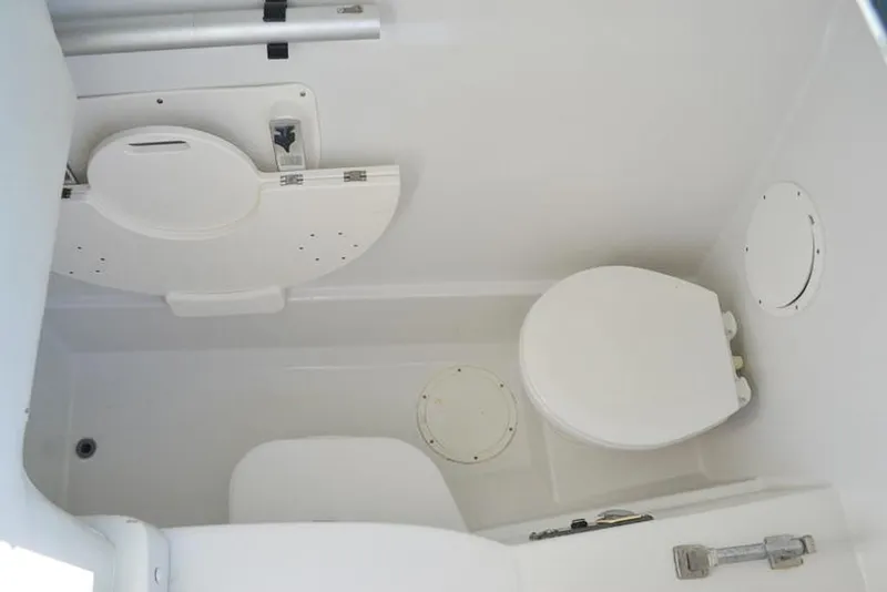 Slide: The Image of 2011 Glacier Bay 2740 Dual Console boat bathroom interior with toilet and storage compartments. - 31