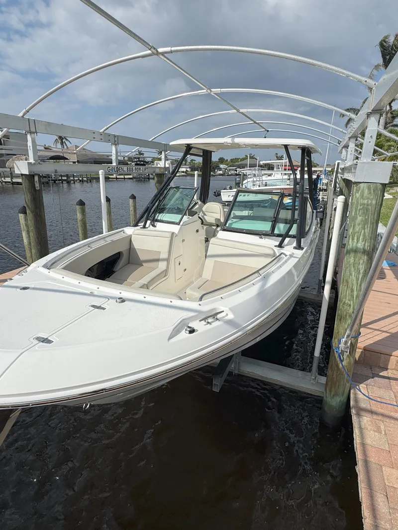 Slide: The Image of 2021 Boston Whaler 240 Vantage boat docked under canopy on water. - 12