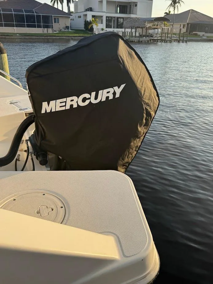 Slide: The Image of 2021 Boston Whaler 240 Vantage with Mercury engine cover, docked by waterfront homes. - 13