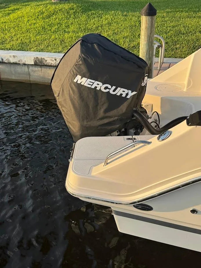 Slide: The Image of 2021 Boston Whaler 240 Vantage with Mercury engine cover, docked by the water. - 14