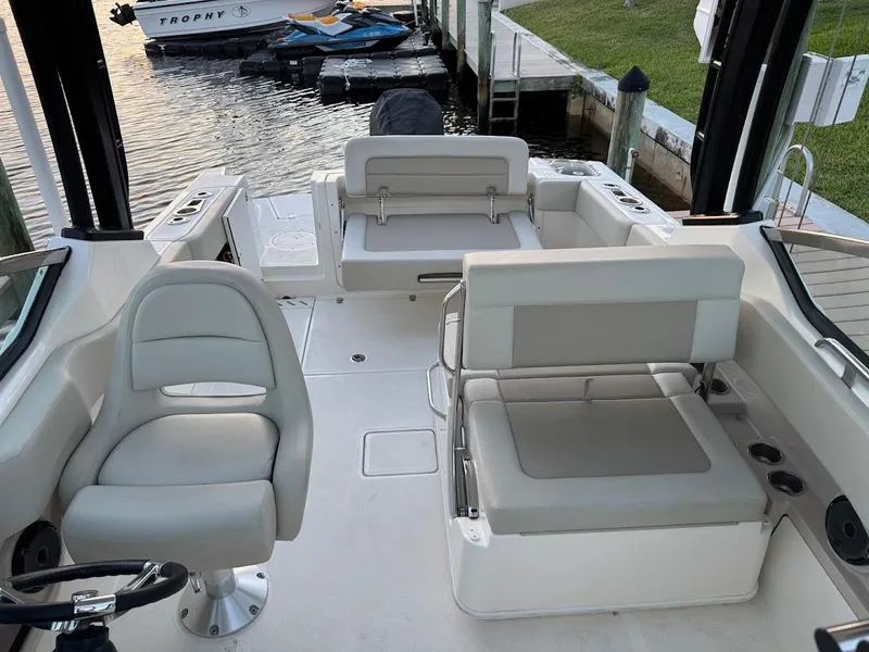 Slide: The Image of 2021 Boston Whaler 240 Vantage boat interior with seating and dock view. - 17
