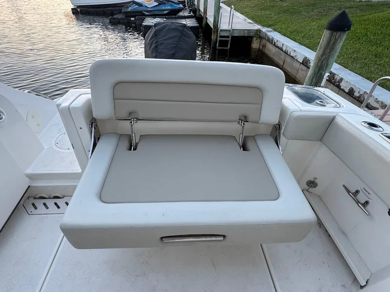 Slide: The Image of Boston Whaler 240 Vantage 2021 boat seat, dockside view, with water and grass background. - 18