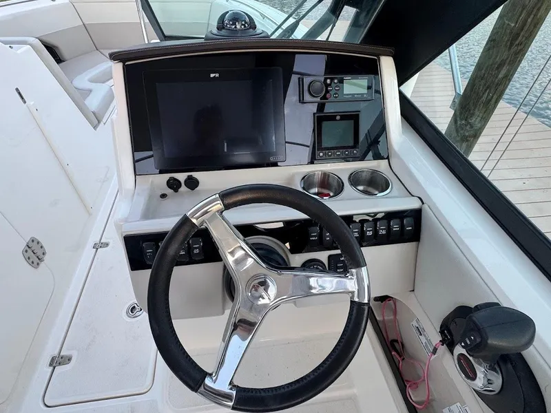 Slide: The Image of 2021 Boston Whaler 240 Vantage helm with steering wheel and navigation controls. - 20