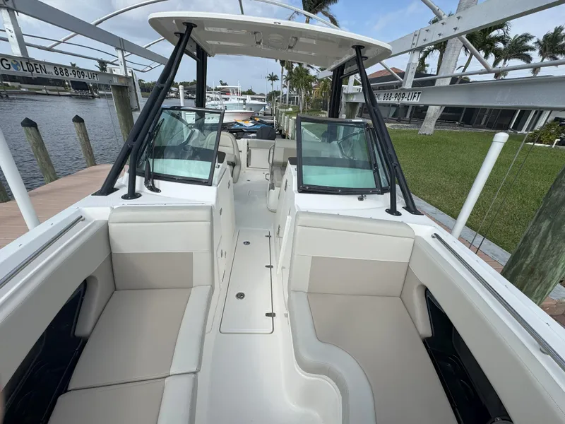 Slide: The Image of 2021 Boston Whaler 240 Vantage boat interior with seating and windshield, docked by the water. - 22