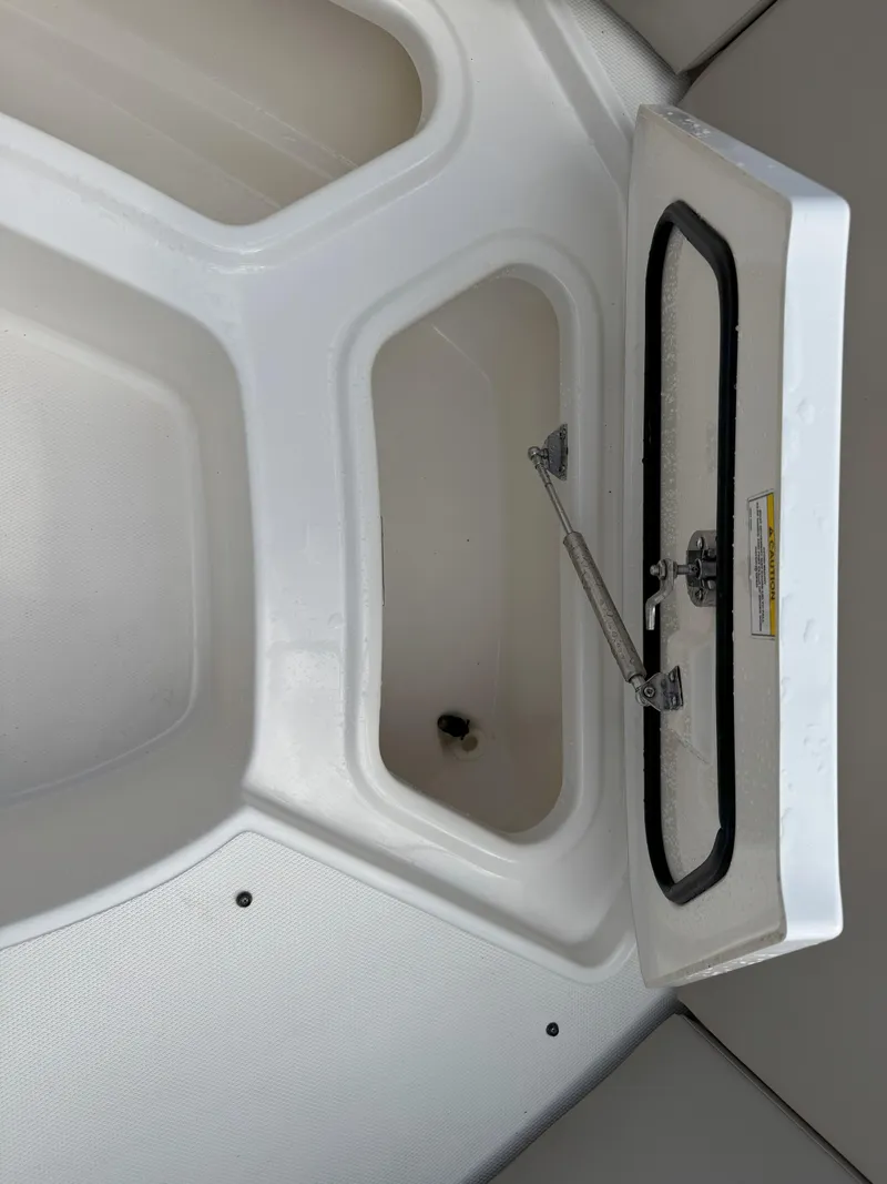 Slide: The Image of 2021 Boston Whaler 240 Vantage storage compartment with open lid. - 27
