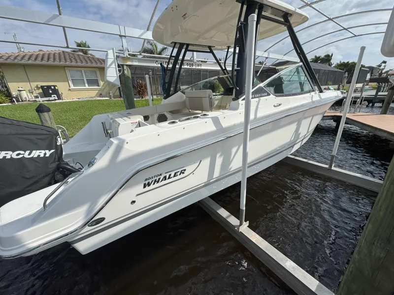 Slide: The Image of 2021 Boston Whaler 240 Vantage boat docked, featuring sleek design and Mercury engine. - 3