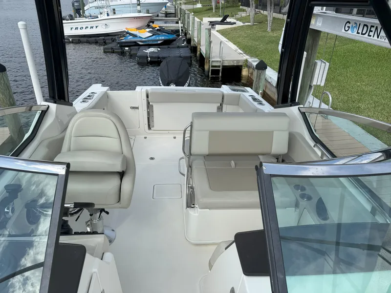Slide: The Image of 2021 Boston Whaler 240 Vantage boat interior with seating, docked by the water. - 37