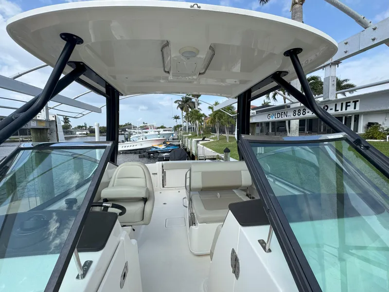 Slide: The Image of 2021 Boston Whaler 240 Vantage boat interior with seating and canopy, docked at marina. - 39