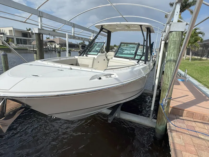 Slide: The Image of 2021 Boston Whaler 240 Vantage boat on lift, docked by waterfront homes. - 4