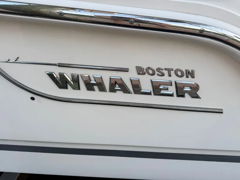 Slide: The Image of Boston Whaler 240 Vantage 2021 boat logo on white hull with chrome accents. - 49