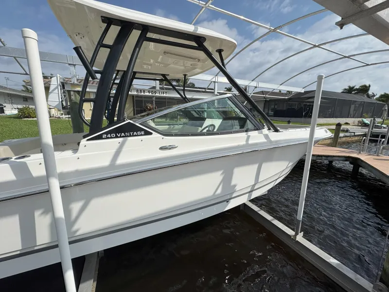Slide: The Image of 2021 Boston Whaler 240 Vantage boat docked under a canopy on a sunny day. - 5