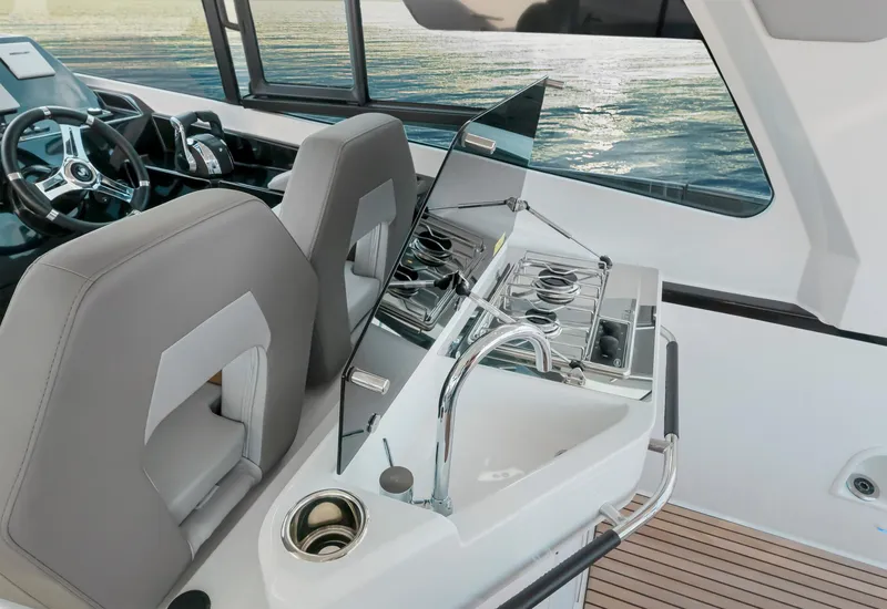 Slide: The Image of 2025 Beneteau 32 Gran Turismo yacht interior with modern kitchen and steering area. - 13