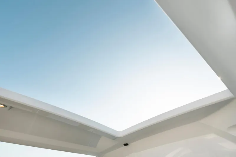 Slide: The Image of Open sunroof of 2025 Beneteau 32 Gran Turismo against clear blue sky. - 15