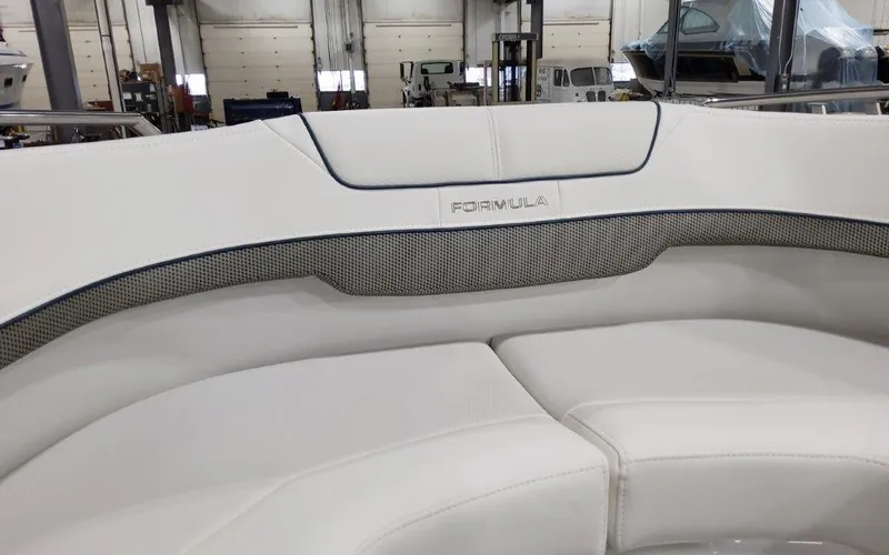 Slide: The Image of 2025 Formula 310 Bowrider I/O boat interior with white seating in a showroom. - 13