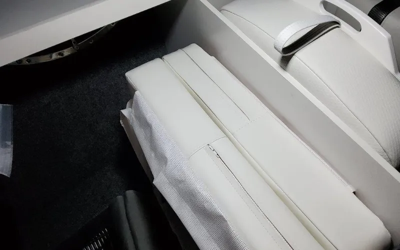 Slide: The Image of 2025 Formula 310 Bowrider I/O interior seating with white upholstery and storage compartment. - 20