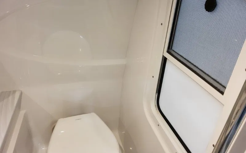 Slide: The Image of Interior of 2025 Formula 310 Bowrider I/O boat bathroom with window and toilet. - 25