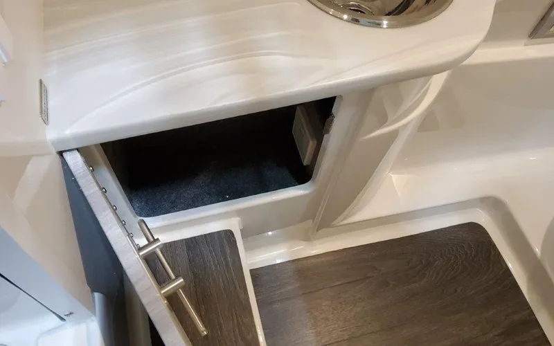 Slide: The Image of 2025 Formula 310 Bowrider I/O interior with open storage compartment and sleek countertop design. - 26