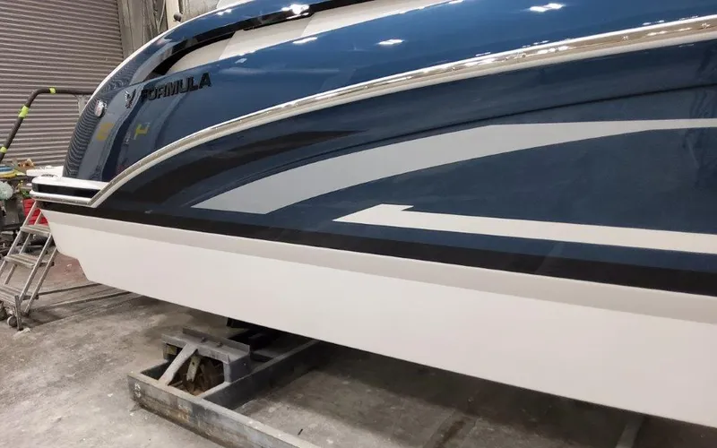 Slide: The Image of 2025 Formula 310 Bowrider I/O boat in a workshop, showcasing sleek blue and white design. - 3