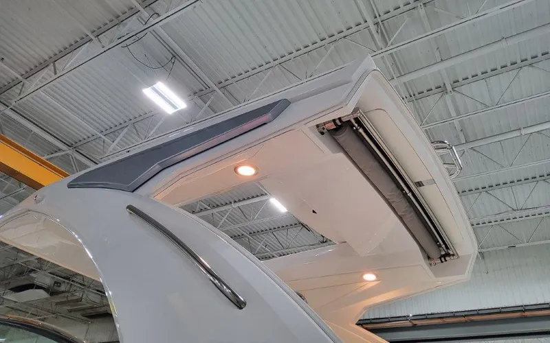 Slide: The Image of 2025 Formula 310 Bowrider I/O boat with sleek design and modern lighting in a warehouse. - 5