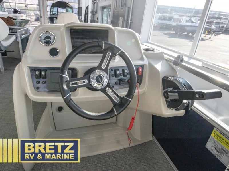 Slide: The Image of Vista Fish 18 boat dashboard, 2025 model, featuring steering wheel and controls at Bretz RV & Marine. - 6