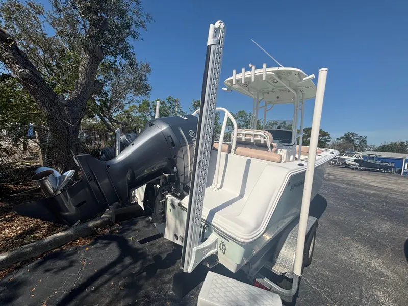Slide: The Image of 2020 Sportsman Heritage 231 Center Console boat with outboard motor, parked on a sunny day. - 2