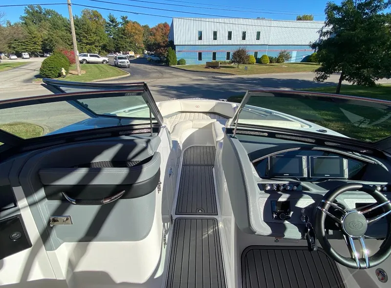 Slide: The Image of 2021 Cobalt R7 boat interior with steering wheel and dashboard, docked outdoors. - 4
