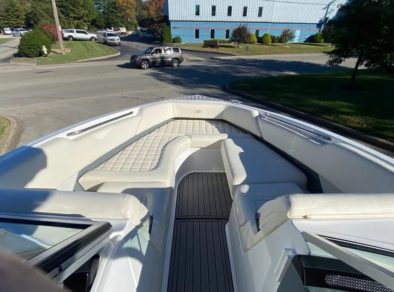 Slide: The Image of 2021 Cobalt R7 boat interior with white seating and black flooring, parked on a street. - 6