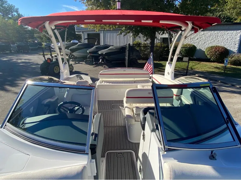 Slide: The Image of 2021 Cobalt R7 boat with red canopy and American flag, parked outdoors. - 7