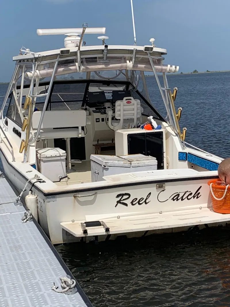 Slide: The Image of 2001 Carolina Classic 28 boat named "Reel Catch" docked by the water. - 1