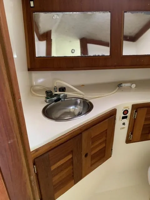 Slide: The Image of 2001 Carolina Classic 28 boat bathroom with sink, wooden cabinets, and mirrors. - 17