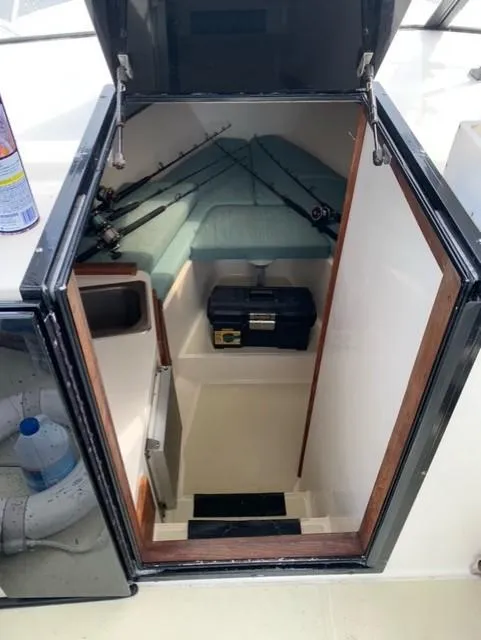 Slide: The Image of 2001 Carolina Classic 28 cabin entrance with fishing gear and storage. - 31