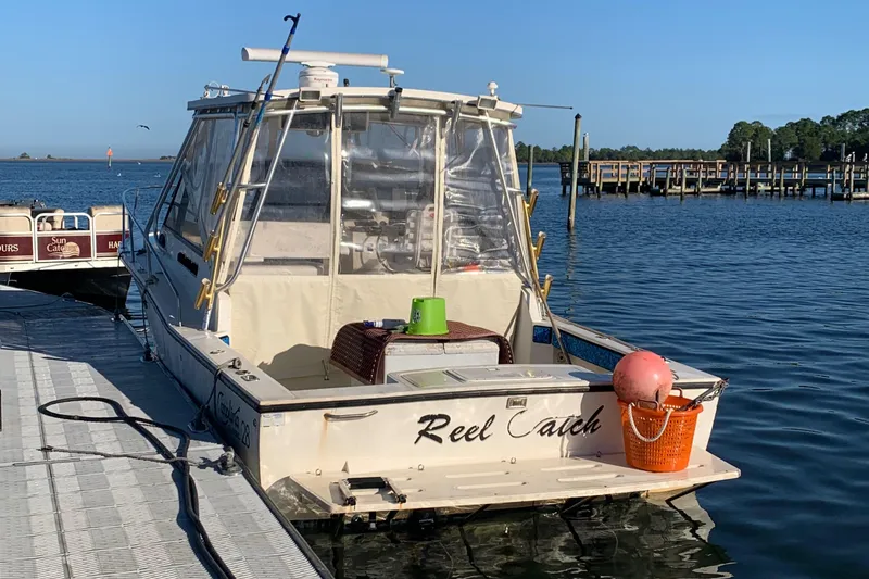 Slide: The Image of 2001 Carolina Classic 28 boat named "Reel Catch" docked at a marina. - 35