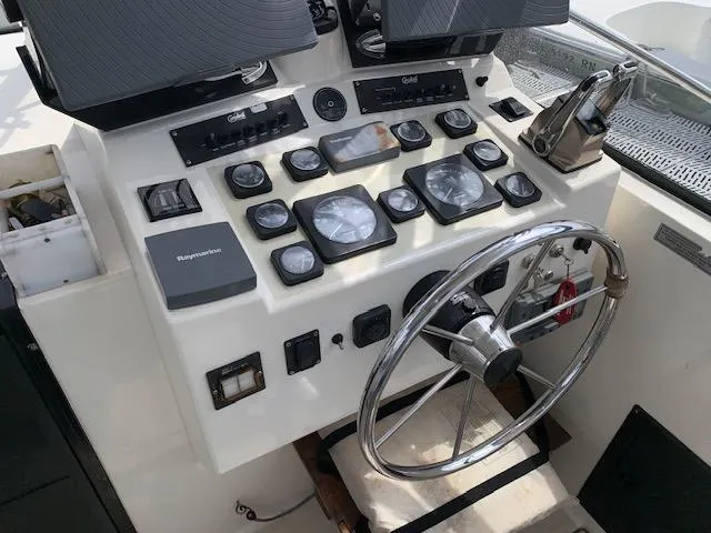 Slide: The Image of Control panel of a 2001 Carolina Classic 28 boat with steering wheel and gauges. - 5