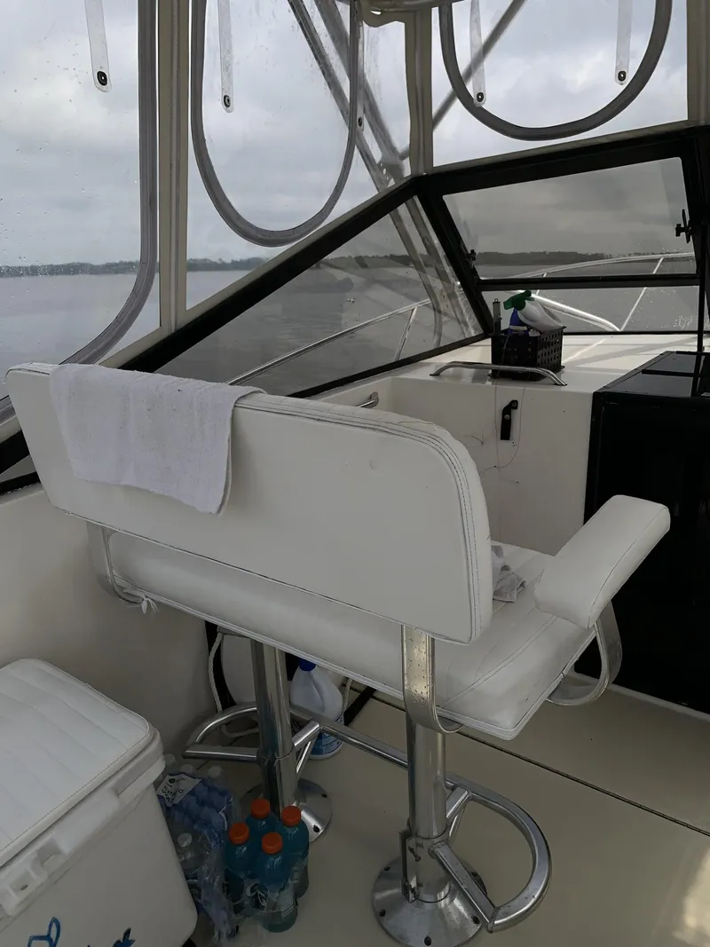Slide: The Image of 2001 Carolina Classic 28 boat interior with white captain's chair and helm station. - 8