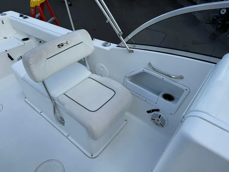 Slide: The Image of 2014 Sea Hunt Escape 235 SE boat interior with white seating and storage compartment. - 12